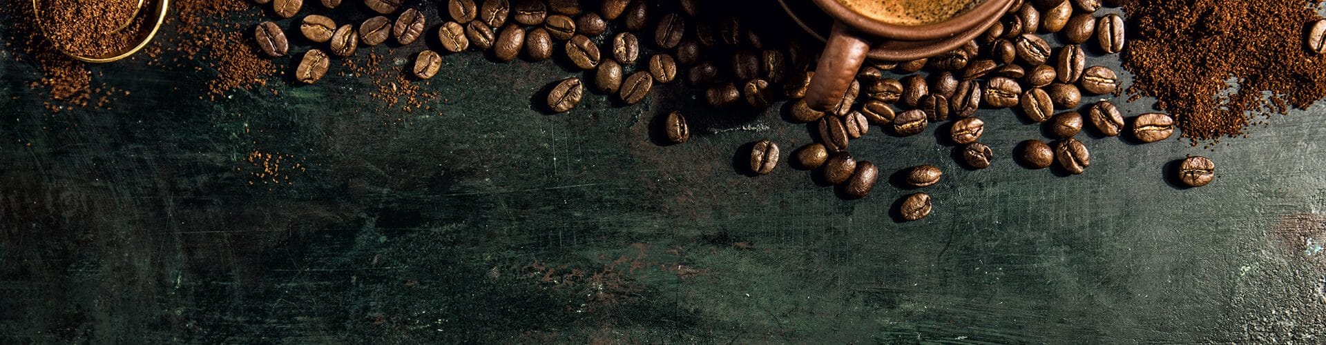 Grãos de café, café em pó e café passado sobre mesa de madeira para ilustrar os benefícios do café