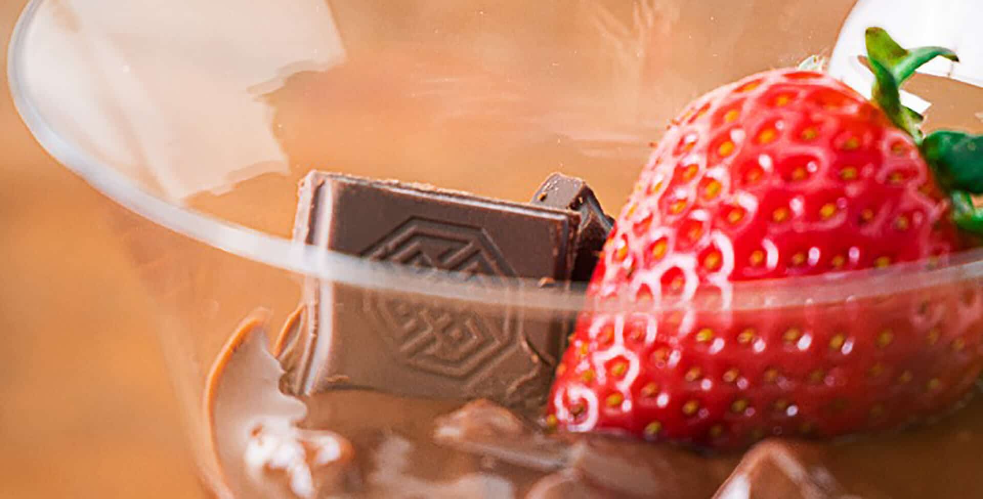 Pedaço de choclate e um morango, que compoem a receita de bombom de morango na taça fit,