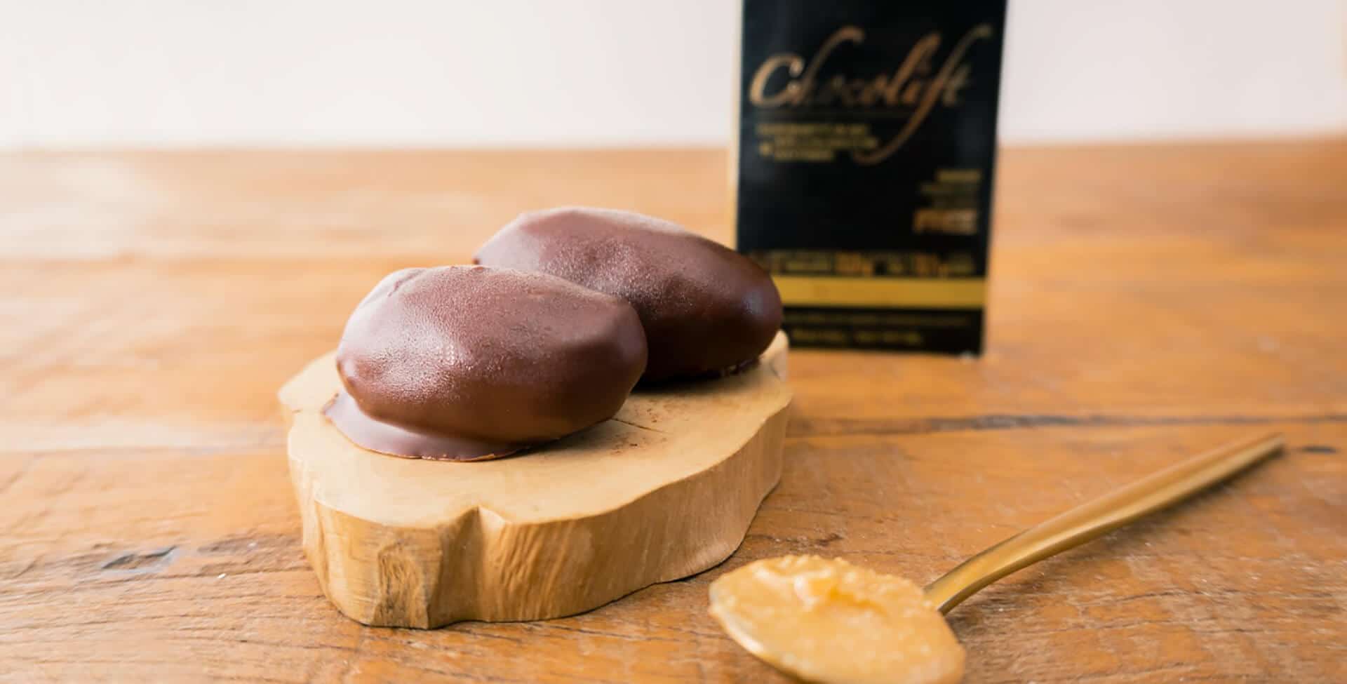 2 brigadeiros de tâmara sob mesa de madeira