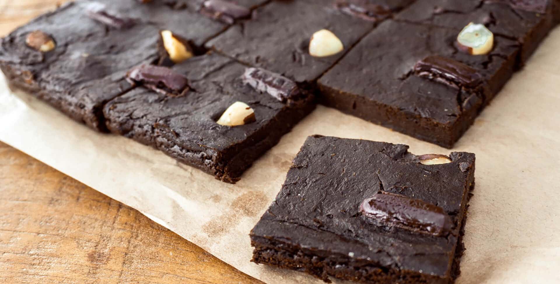 pedaços de brownie sem açúcar em uma mesa de madeira, sob um papel pardo
