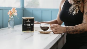 Mulher estudando e tomando o supercafé Brainstorm Coffee para melhorar o foco e a concentração.