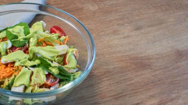 Bowl com folhas, legumes e molho de abacate para salada.