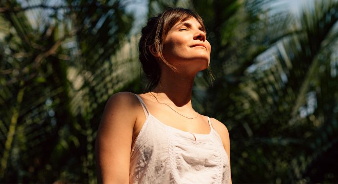 Mulher de olhos fechados, aproveitando a luz do sol