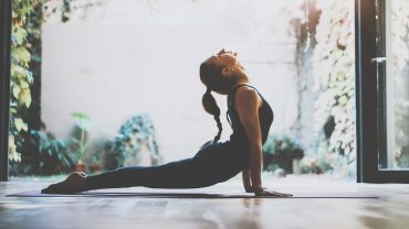 Mulher apoiada no chão realizando um treino de mobilidade.