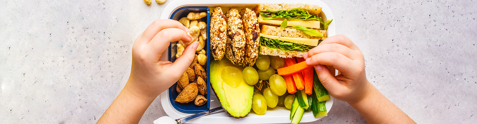 Lancheira saudável com oleaginosas, pão, cookies, frutas e vegetais.