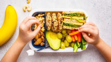 Lancheira saudável com oleaginosas, pão, cookies, frutas e vegetais.