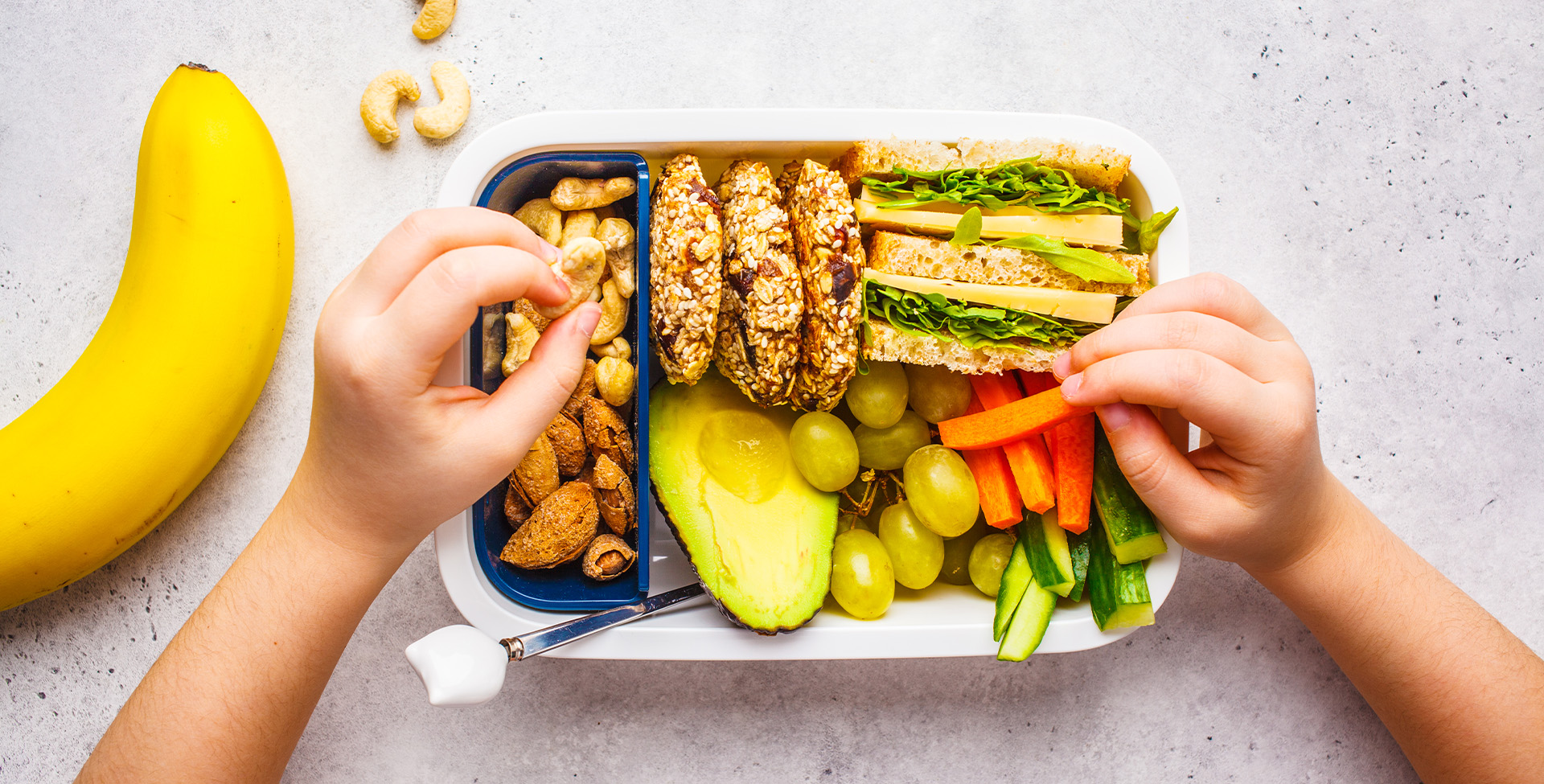 Lancheira saudável com oleaginosas, pão, cookies, frutas e vegetais.