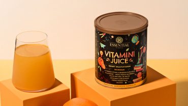 Um copo com suco e uma lata de Vitamini Juice sabor laranja