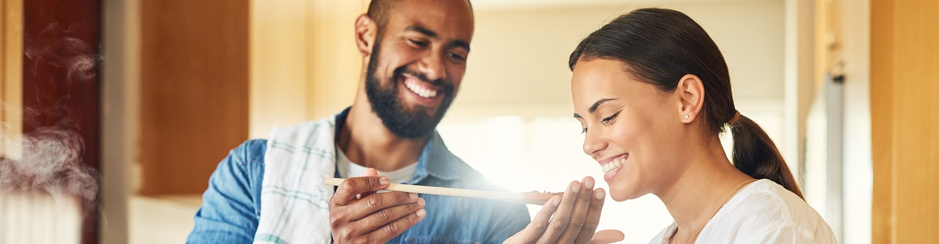 Homem e mulher na cozinha provando receitas para o dia dos namorados